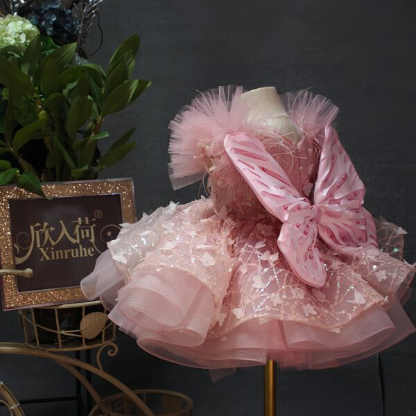 A one-year-old girl wore a pink short butterfly dress, a princess dress and a puffy dress to host a sweet stage performance