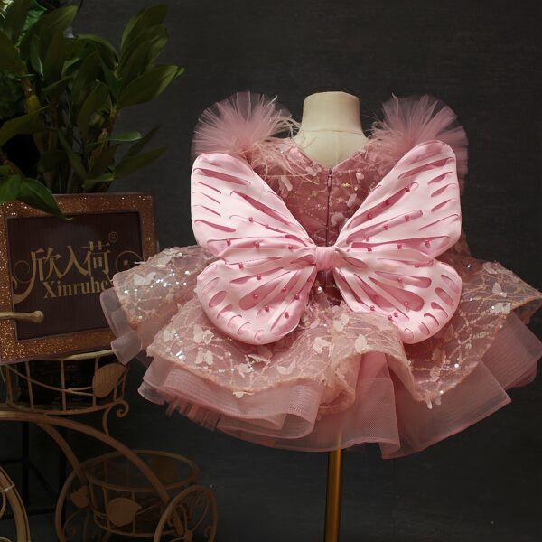 A one-year-old girl wore a pink short butterfly dress, a princess dress and a puffy dress to host a sweet stage performance