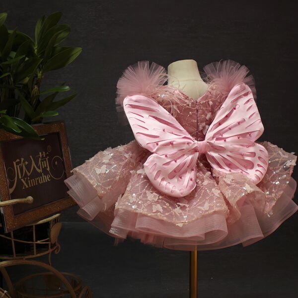 A one-year-old girl wore a pink short butterfly dress, a princess dress and a puffy dress to host a sweet stage performance