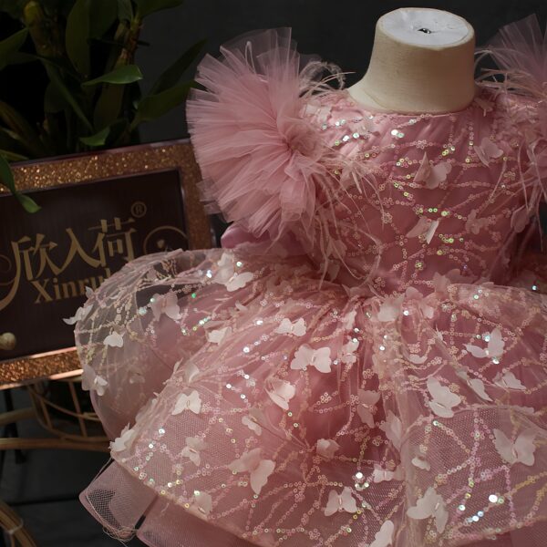 A one-year-old girl wore a pink short butterfly dress, a princess dress and a puffy dress to host a sweet stage performance